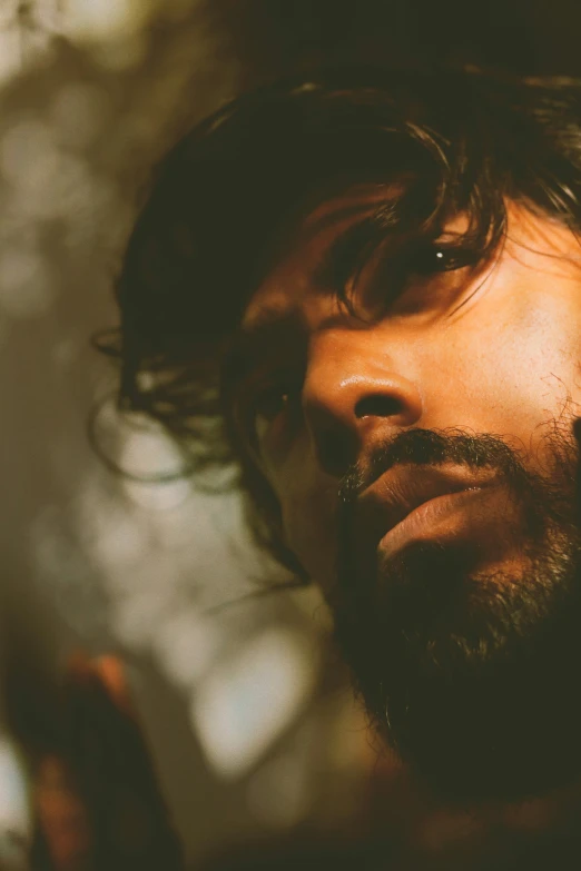 a man with long hair and beard looks up