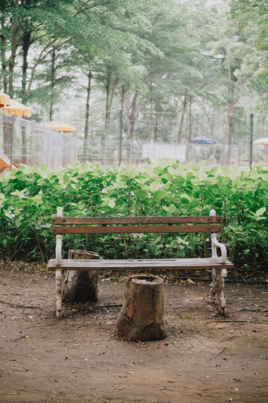 an old park bench with an umbrella hanging over it