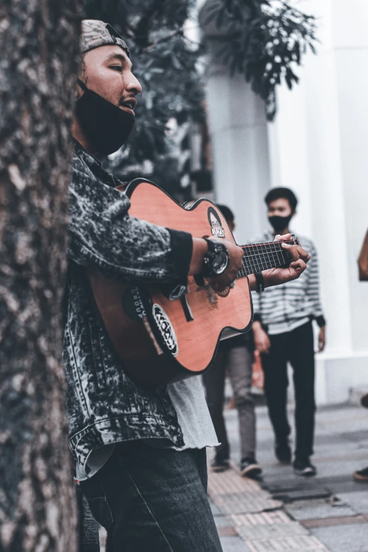 some people are on the side walk playing guitar