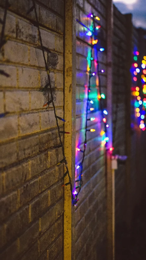 a pole on the side of a building in front of colorful lights