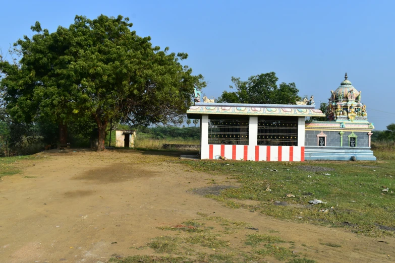 a very small colorful structure on a dirt road