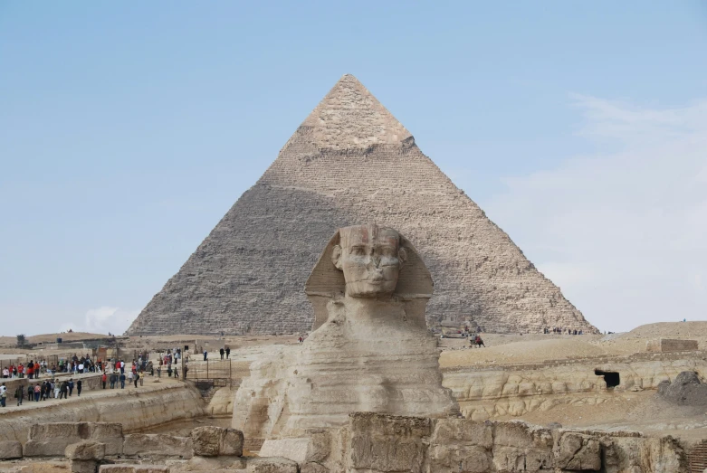 two giraffe statues sit in front of a pyramid