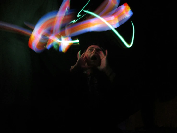 man doing light painting in dark with blurry motion