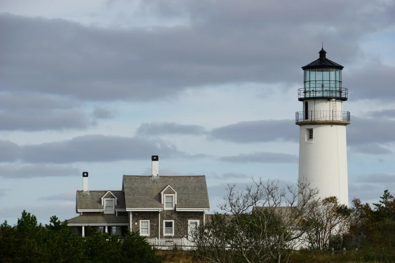 a white lighthouse stands out against the clouds