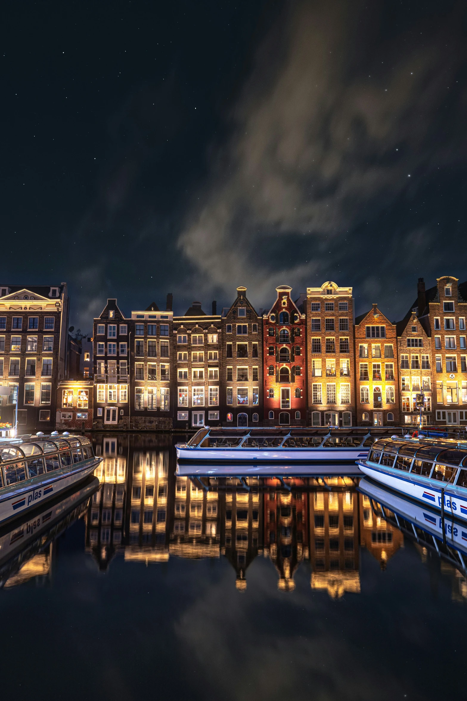 a night scene with boats and a city