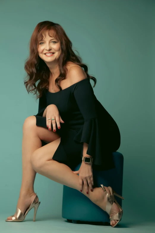 a woman poses with her legs on the side of a luggage bag