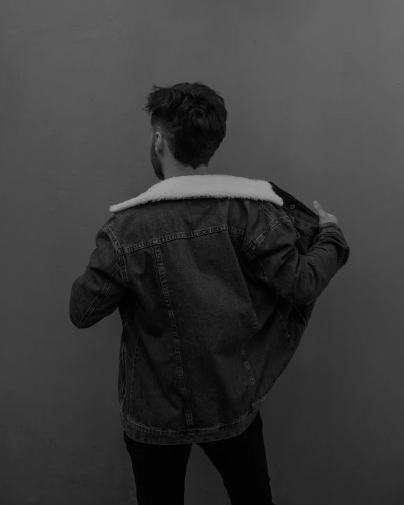 the back of a person wearing a denim jacket with an open hood