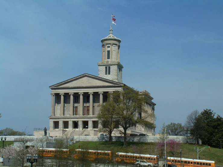 a church with trees, buildings and busses around