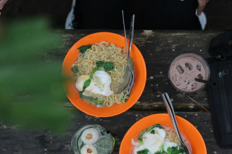 two bowls of food with broccoli on top, one bowl has noodles and the other is soup