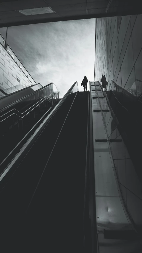 people riding down the escalator of an escalator in black and white