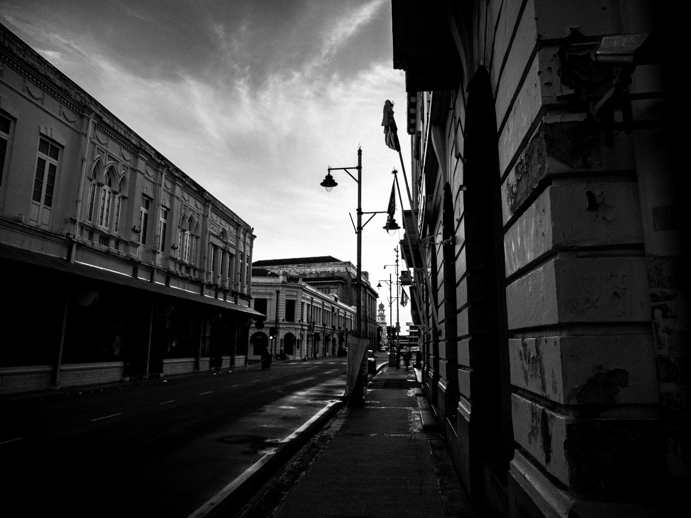 a dark and gloomy city street that has some buildings