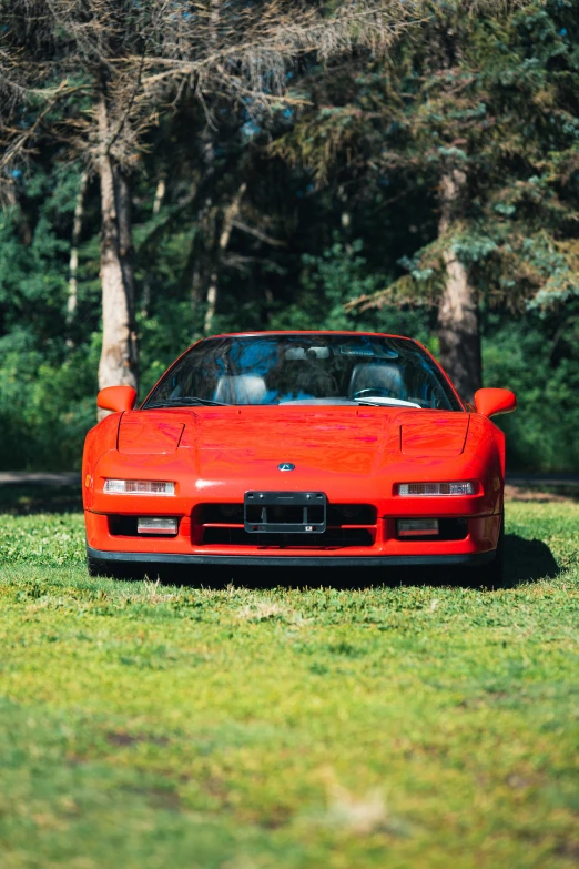 a red car that is sitting on some grass