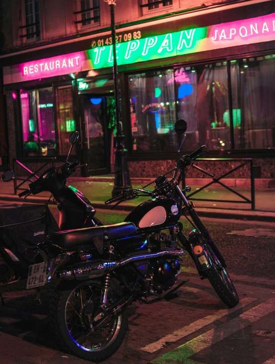 a motorcycle is parked outside of a neon restaurant