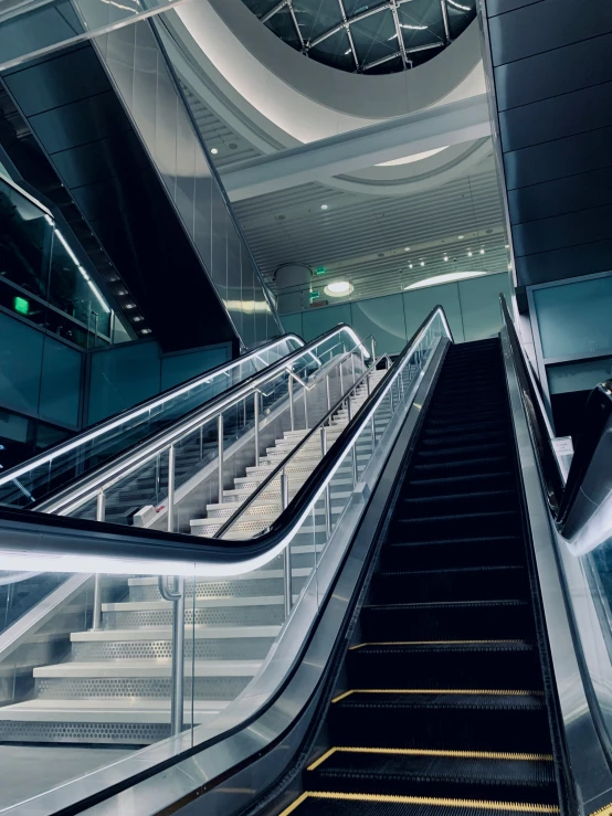 a escalator in a modern building with the light from above