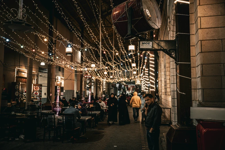 a dark street at night filled with people walking and drinking