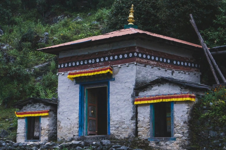 a small house made of stone with colorful stripes painted on it