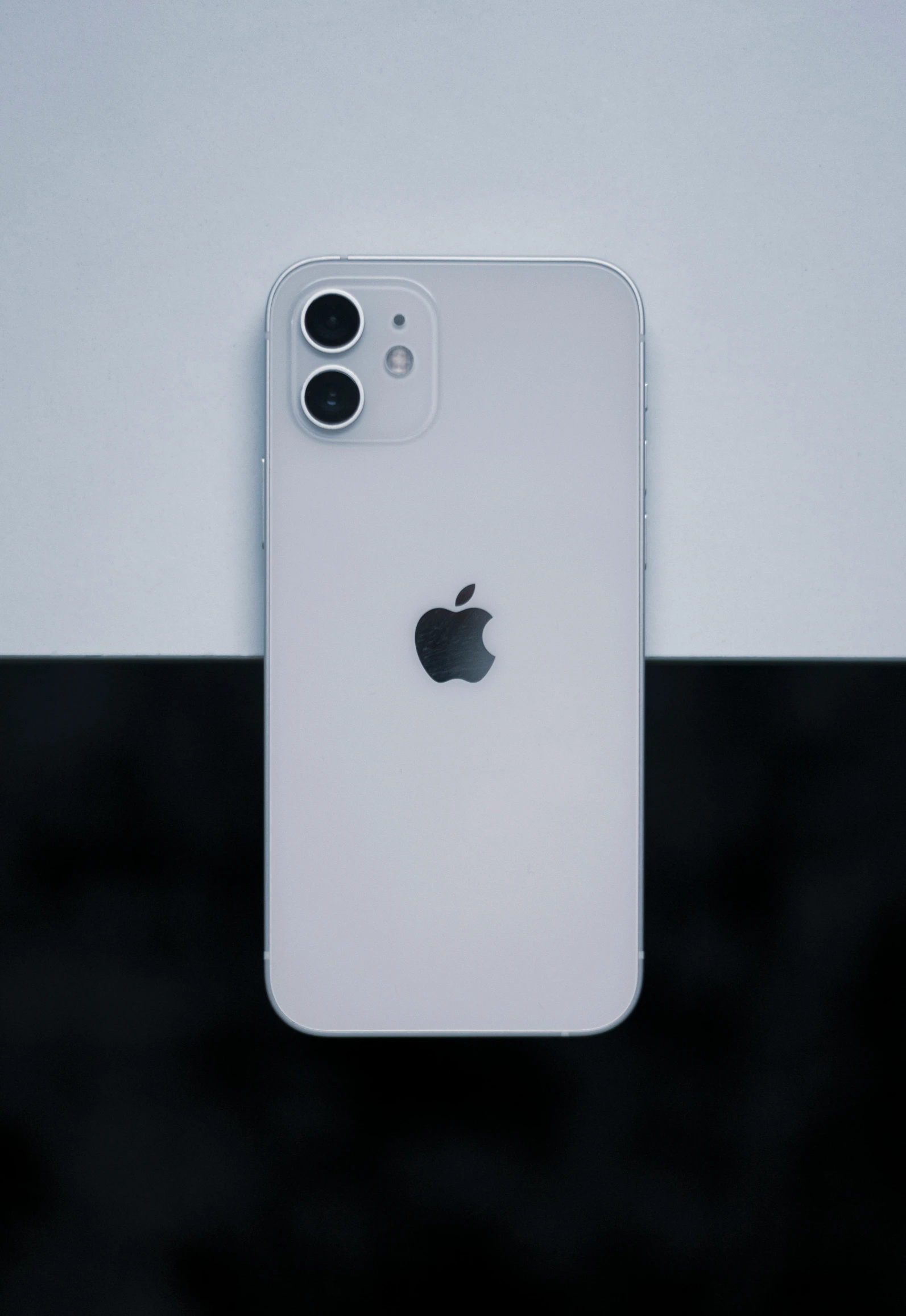 an iphone sitting up against a white wall