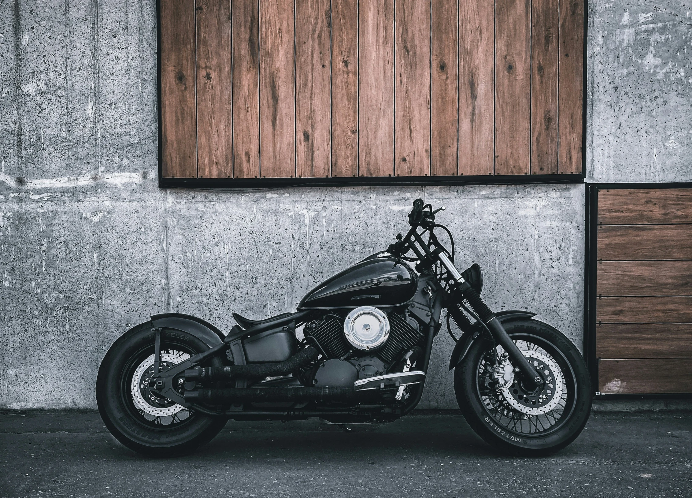 motorcycle parked outside a building near some wooden doors