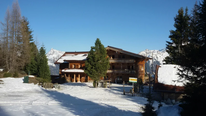 a wooden building surrounded by evergreen trees in the snow