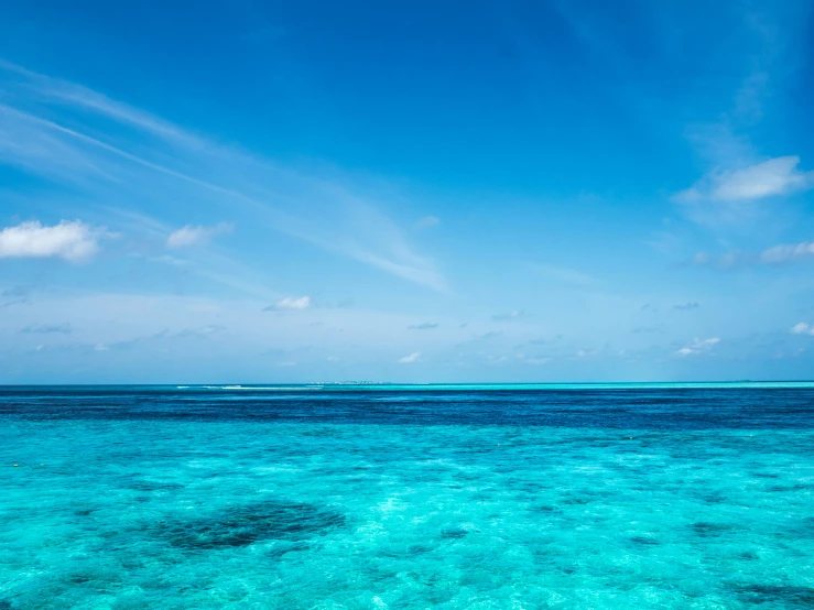 the ocean has blue water and small boats