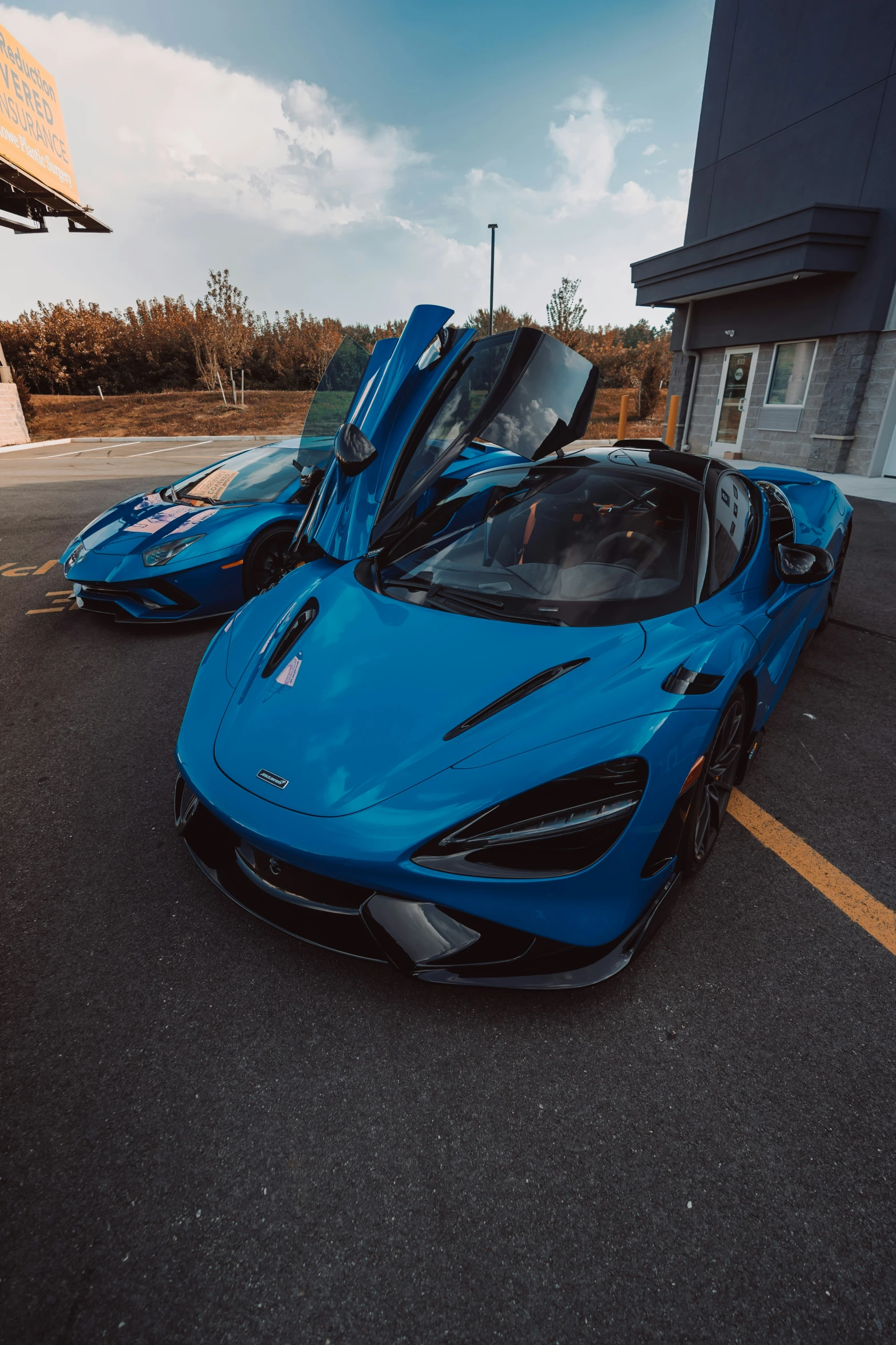 the front of a blue sports car parked next to another blue sport car