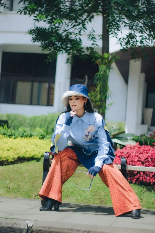 the woman is posing on a bench by the house