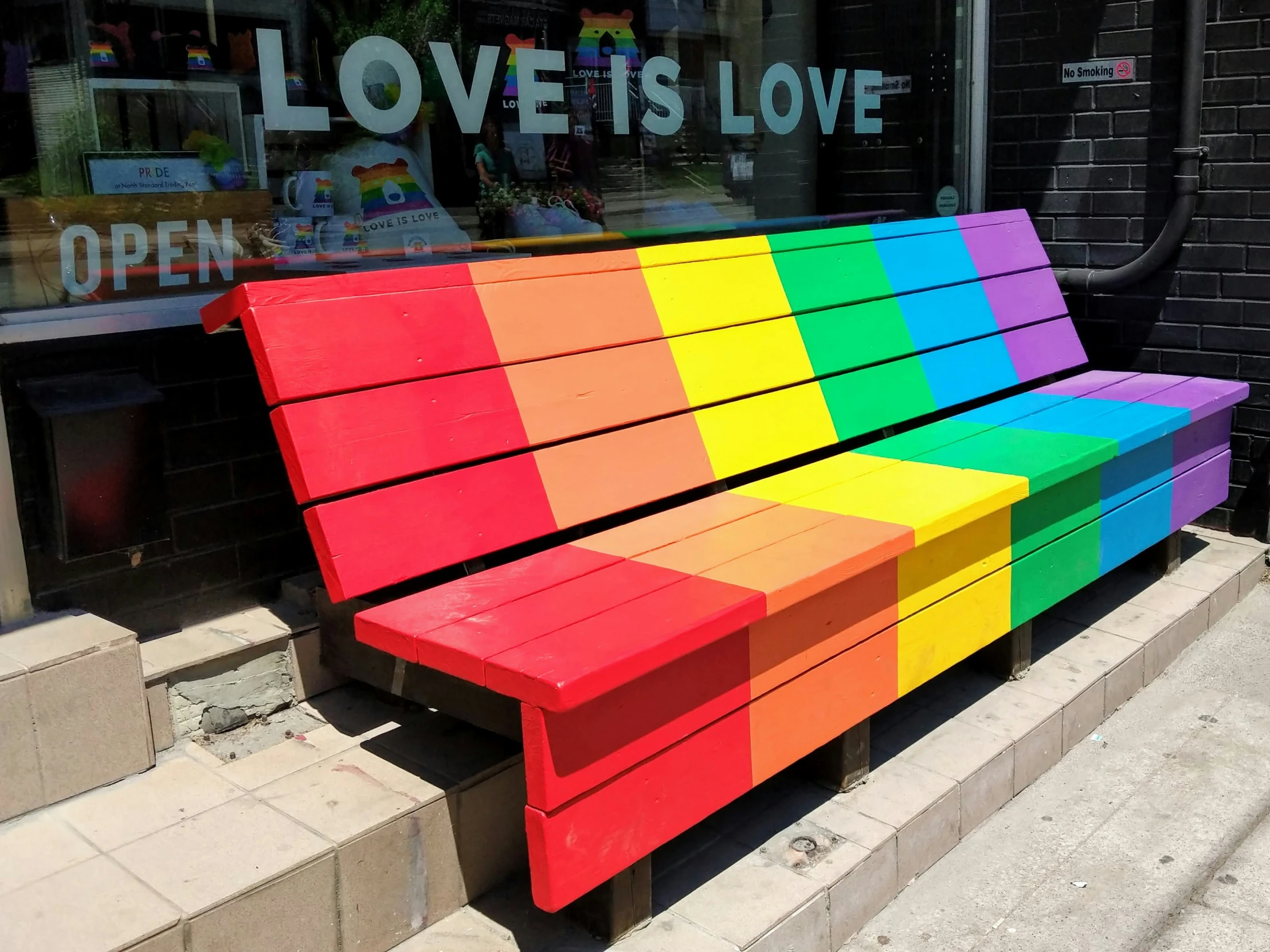 there is a bench that is painted like a rainbow