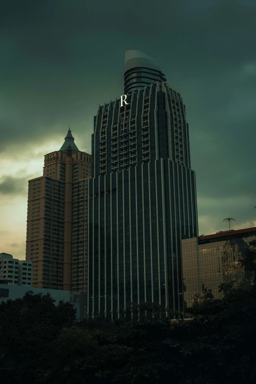 a tall skyscr in front of some buildings under a cloudy sky