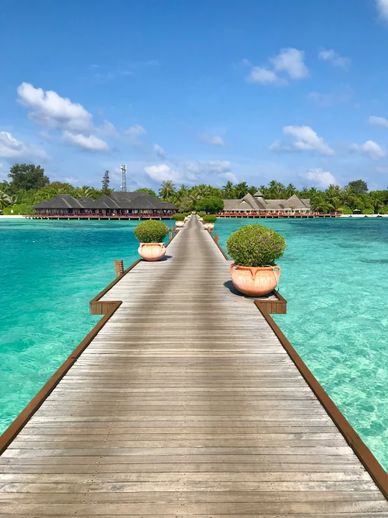 a wooden bridge leading into some pretty turquoise water