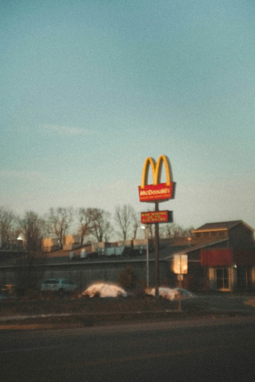 a restaurant sign is next to cars near a mcdonald's