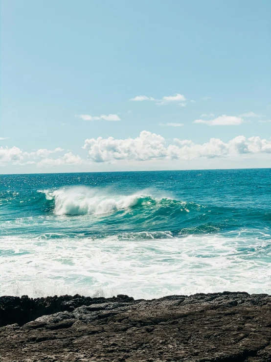 an ocean scene with waves crashing and people watching