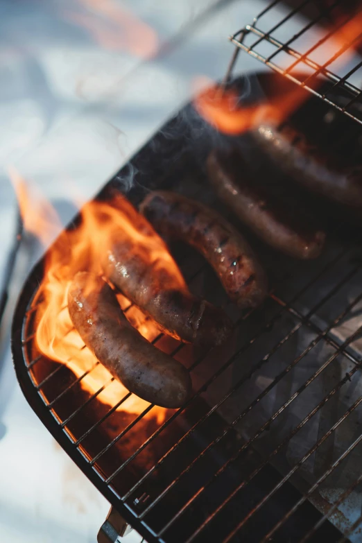  dogs cooking on an outdoor bbq grill