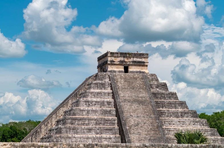 a very tall and skinny pyramid near a forest