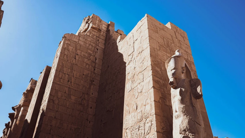 looking up at two tall towers with statues on them