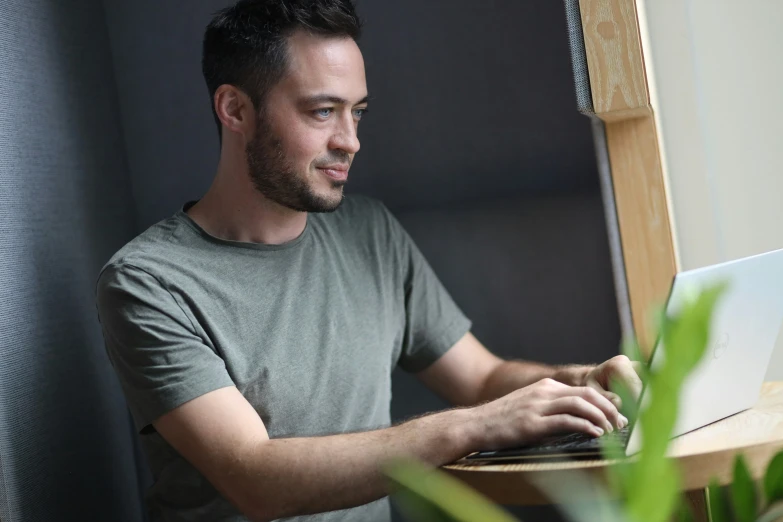 a man with dark hair works on his computer