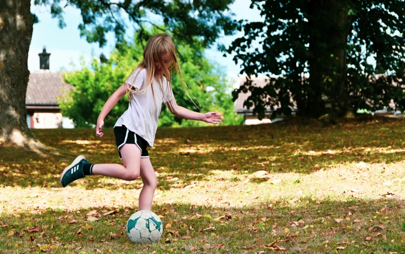 a  kicking a soccer ball around a field