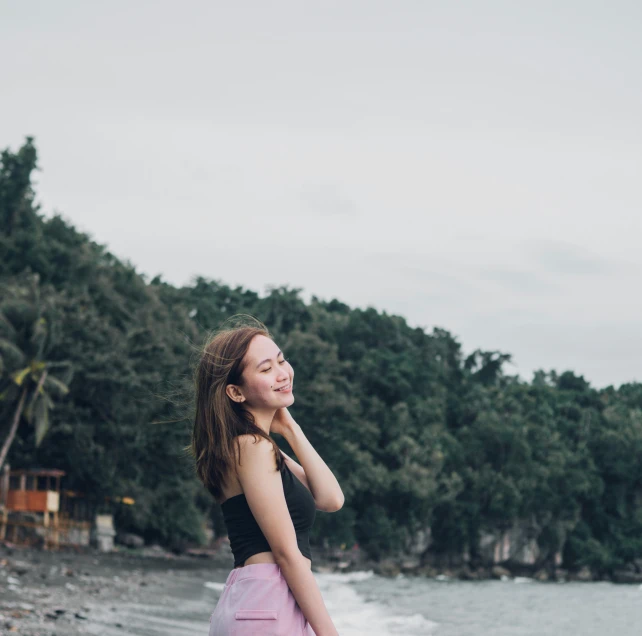 a woman in pink skirt smiling next to water