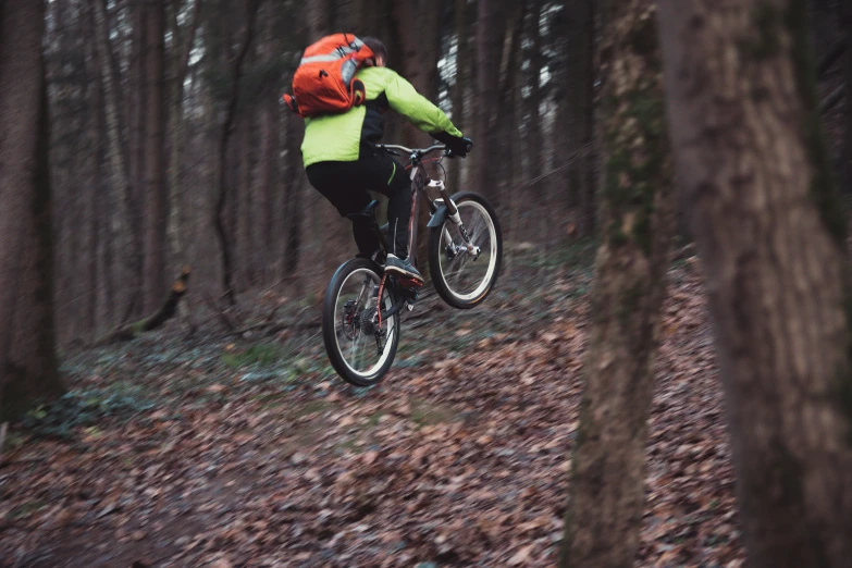 a person in an orange hat is jumping on a bike