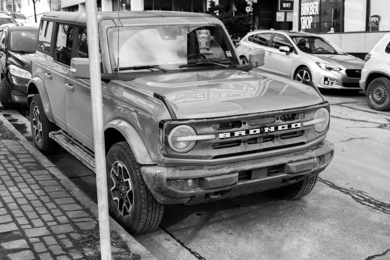 a jeep parked along the side of a road in front of a store