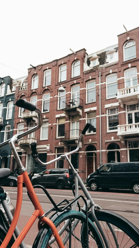 two bicycles are parked by the curb near a building