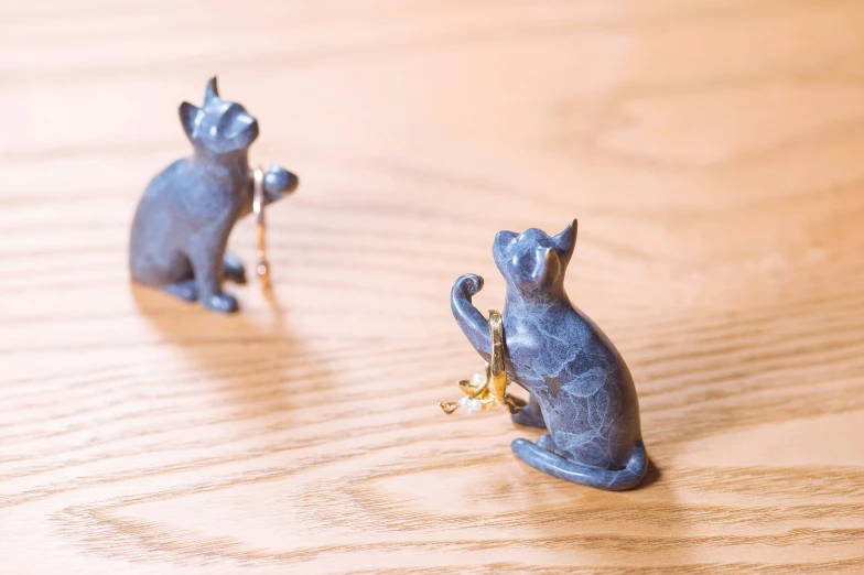 two small ceramic animals sitting on top of a wooden table