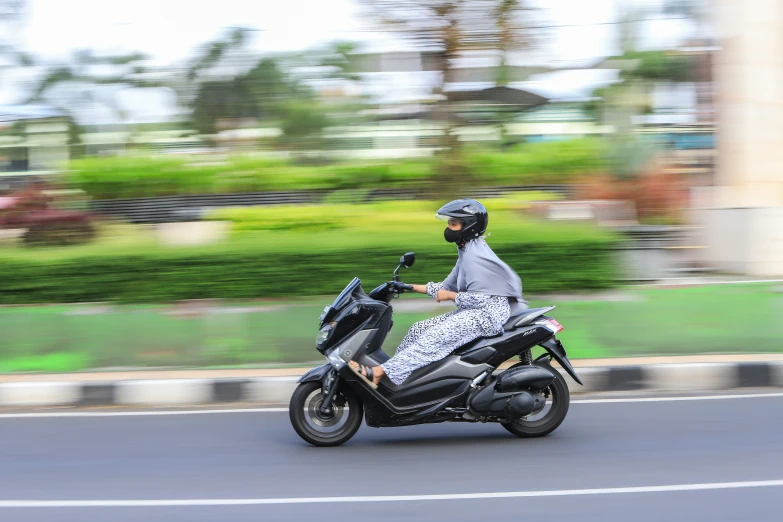 a person on a motorcycle rides down the road