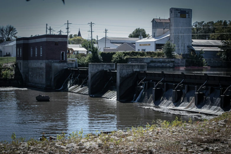 a dam on the edge of a river next to houses