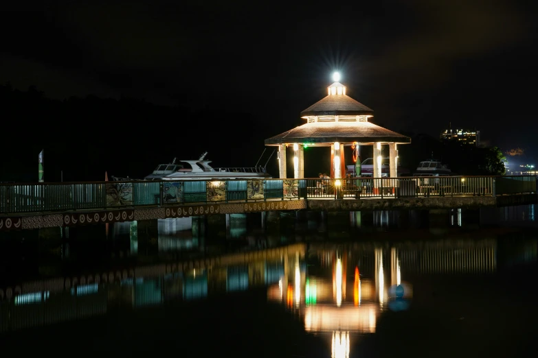 there is a gazebo by the river that is lit up