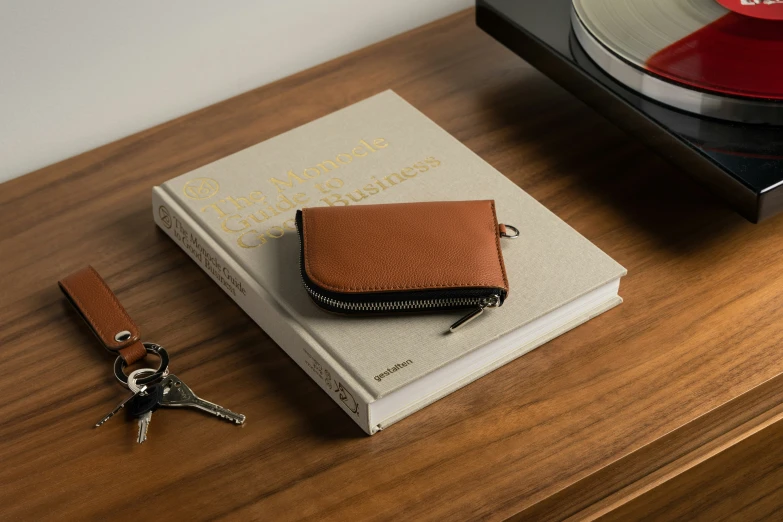 two books and two keys on a desk with a record