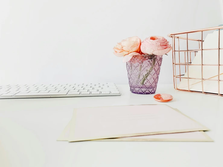 there is a flower in a glass on the desk