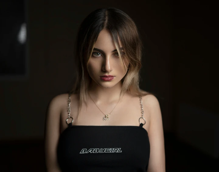 a woman wearing a black top with a chain around her neck
