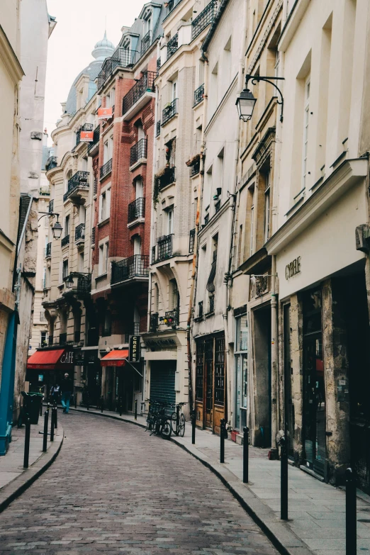 the sidewalk is made of cobblestone in the middle of several buildings