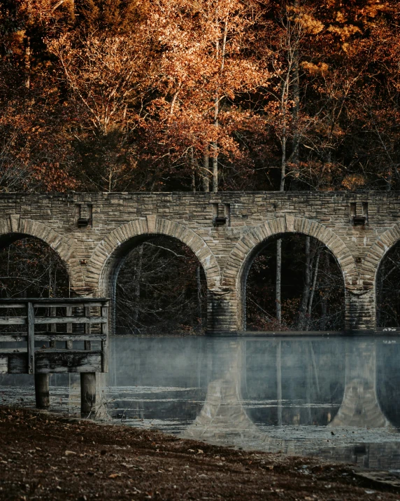 a dock with water near an old stone bridge