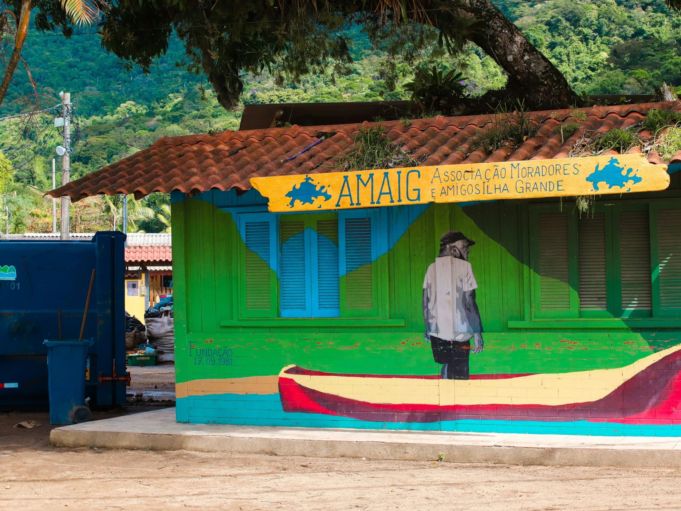 a picture of a man standing in front of a colorful painted building